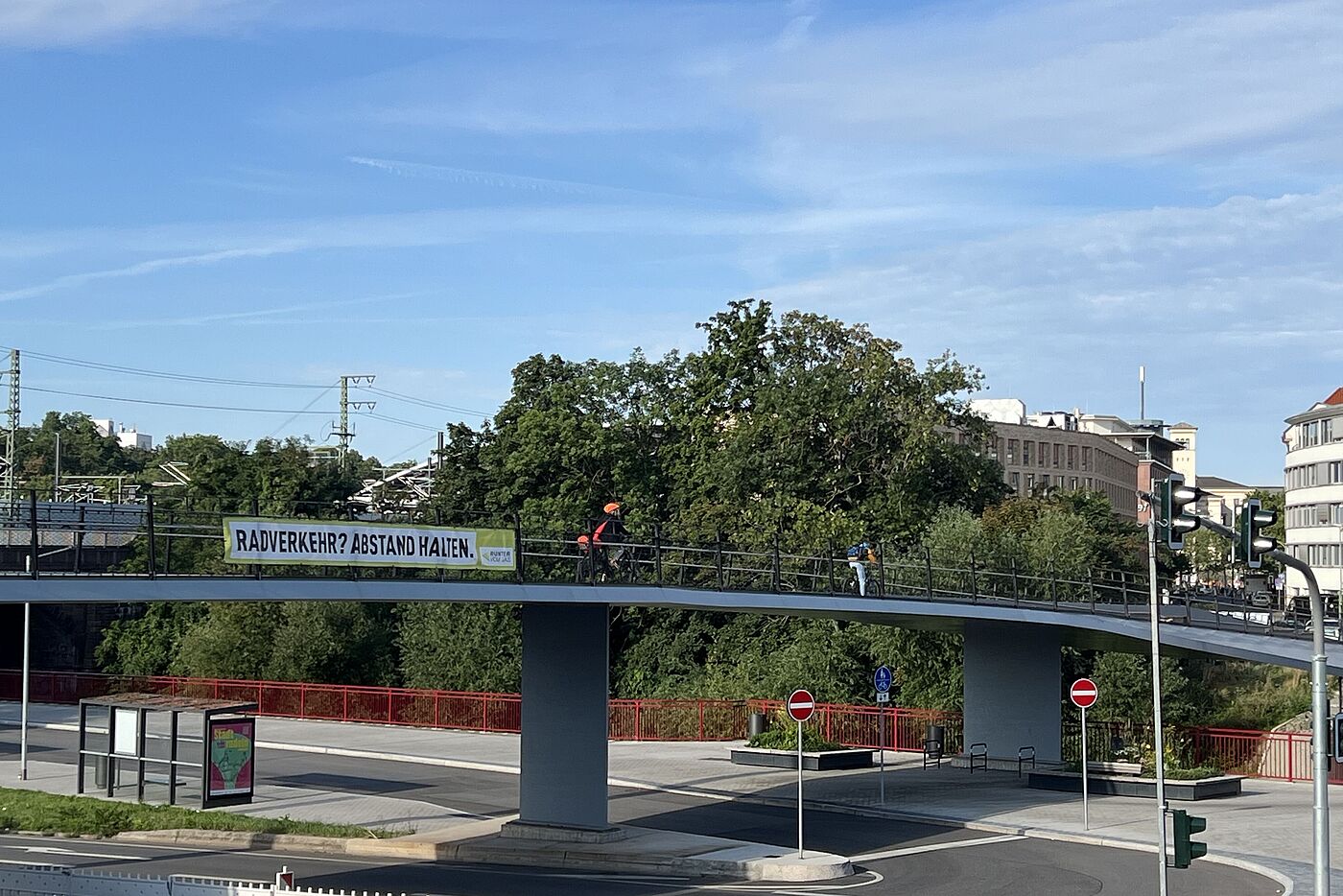 Ein Banner an einem Brückengeländer macht auf den beim Überholen von Radfahrenden einzuhaltenden Abstand aufmerksam