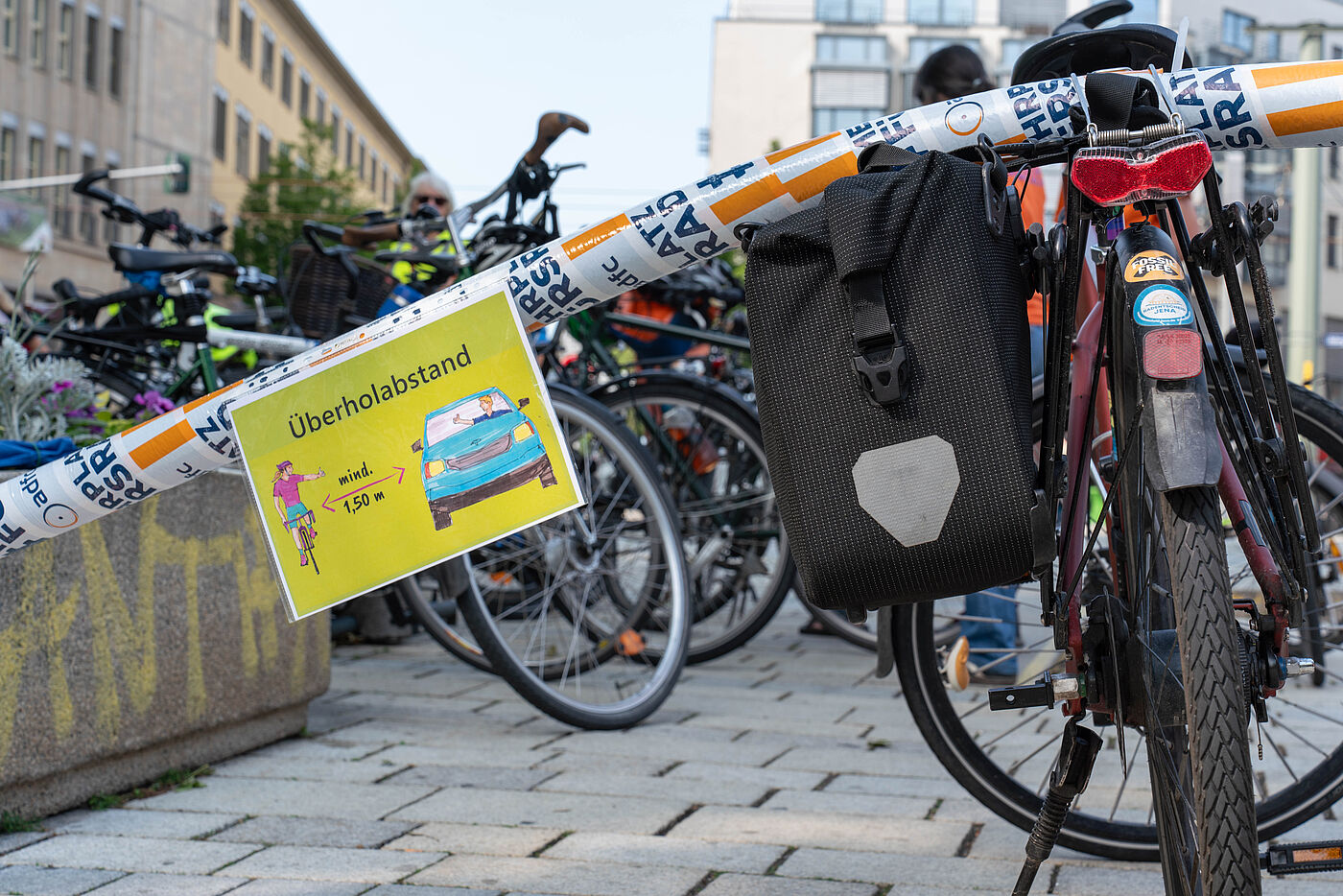 Fahrrad mit einer Poolnudel auf dem Gepäckträger, die signalisiert: 1,5m Mindestabstand beim Überholen.